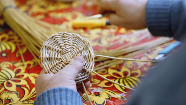 person weaving rattan