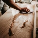 person cleaning wooden table