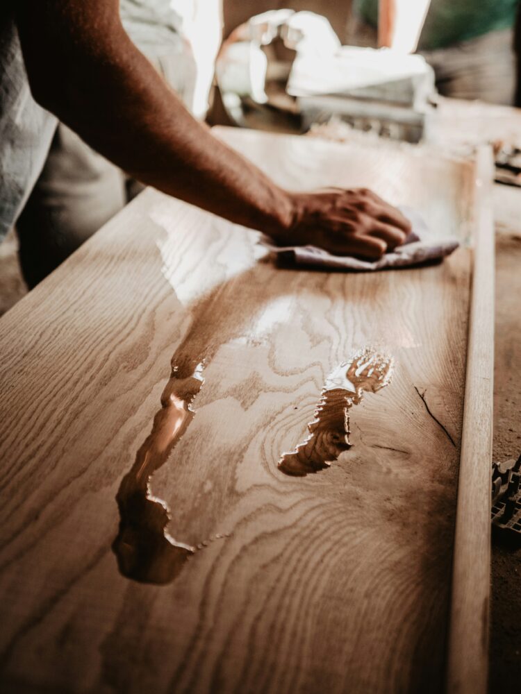 person cleaning wooden table